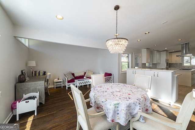 dining area featuring a notable chandelier, sink, and dark wood-type flooring