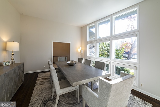 dining area featuring dark hardwood / wood-style floors and vaulted ceiling