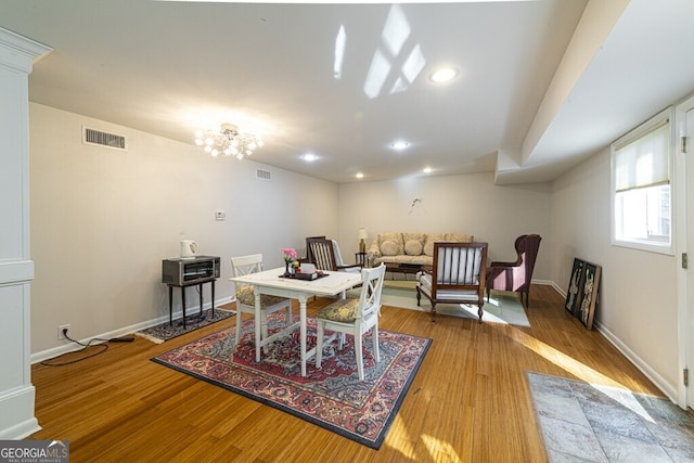 dining space with a notable chandelier and light hardwood / wood-style flooring