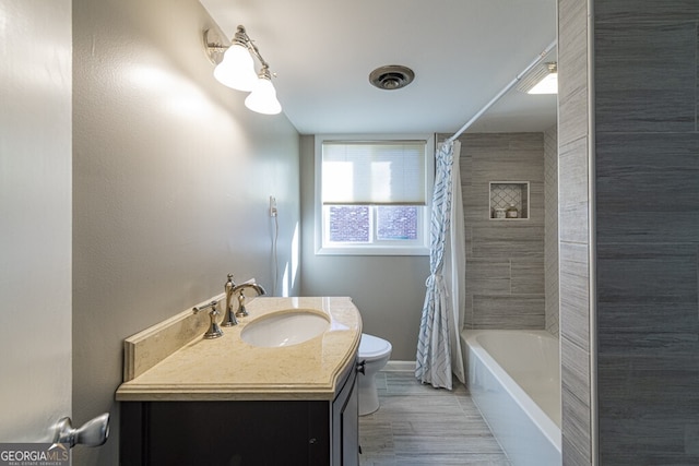 full bathroom featuring hardwood / wood-style floors, vanity, toilet, and shower / bath combo with shower curtain