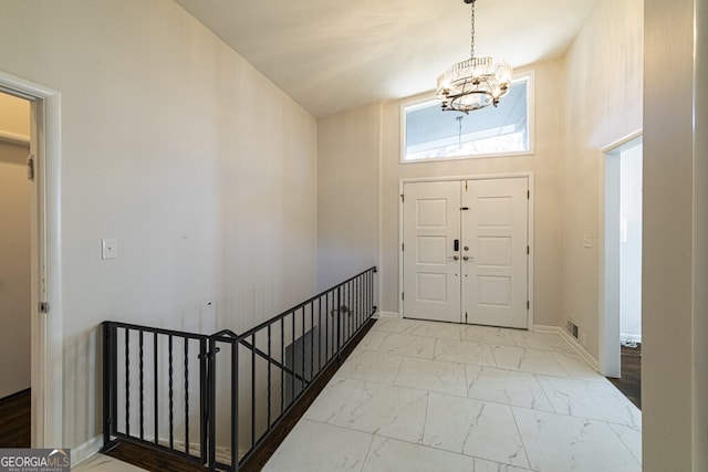 foyer with high vaulted ceiling and a notable chandelier