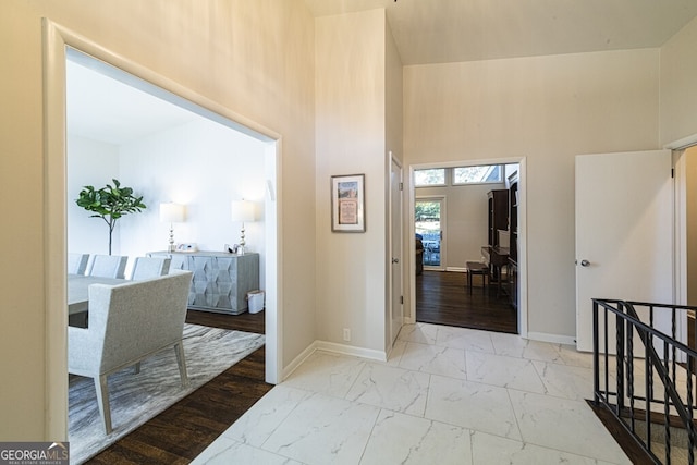 hallway with light hardwood / wood-style floors and a high ceiling