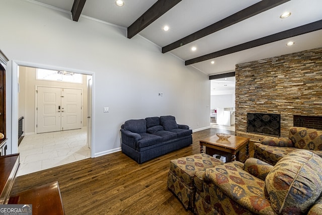 living room with a fireplace, lofted ceiling with beams, light hardwood / wood-style floors, and plenty of natural light