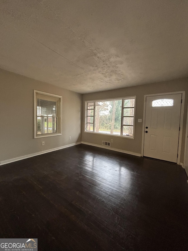 foyer featuring a textured ceiling and dark hardwood / wood-style flooring