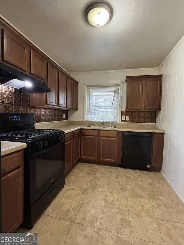 kitchen with dark brown cabinets, sink, light tile patterned floors, and black appliances