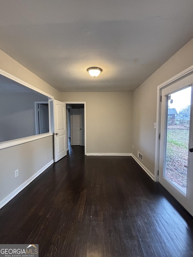 empty room with dark wood-type flooring