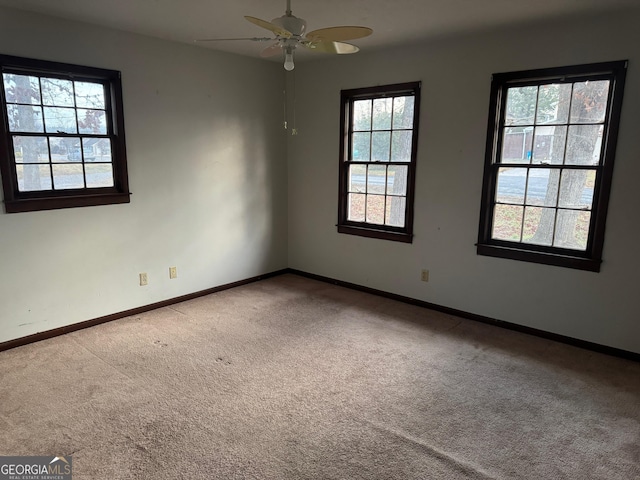 carpeted spare room featuring ceiling fan