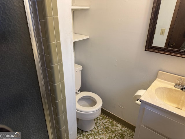 bathroom with vanity, toilet, and a shower with door