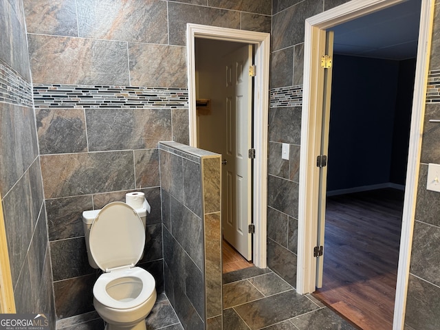 bathroom with tile walls and toilet