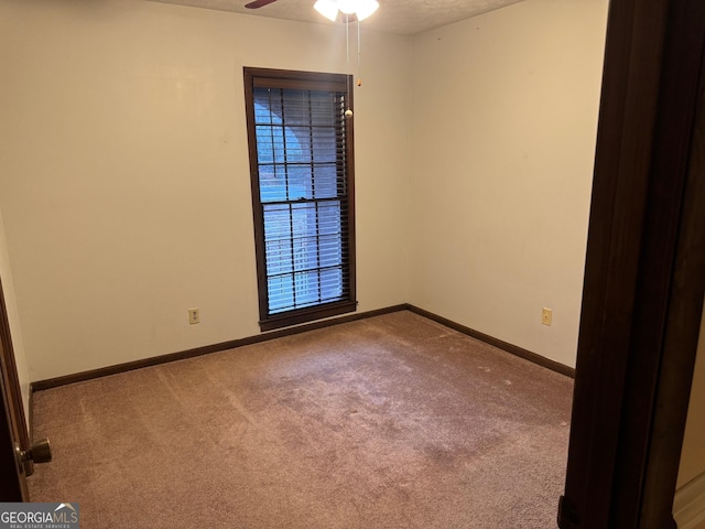 spare room with ceiling fan, light colored carpet, and a textured ceiling