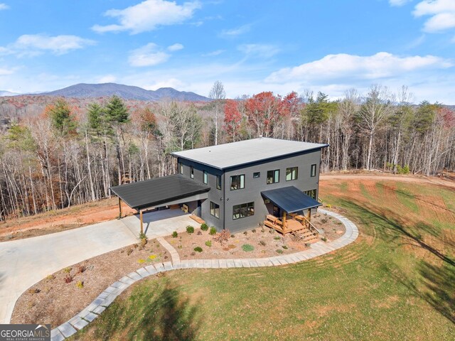 rear view of house with a yard, a carport, and a wooden deck