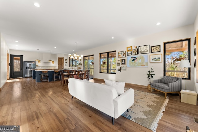 living room featuring wood-type flooring and a chandelier