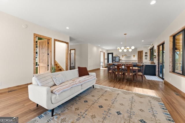 living room featuring light wood-type flooring and a chandelier