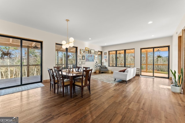 dining space with hardwood / wood-style floors and a notable chandelier