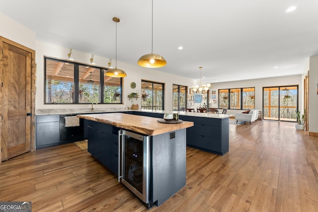 kitchen featuring a notable chandelier, a center island, beverage cooler, and pendant lighting