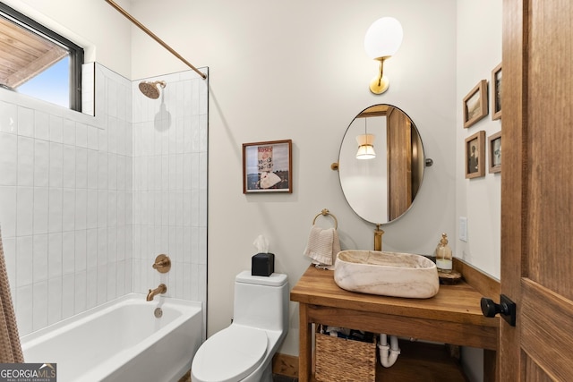 full bathroom featuring tiled shower / bath combo, sink, and toilet