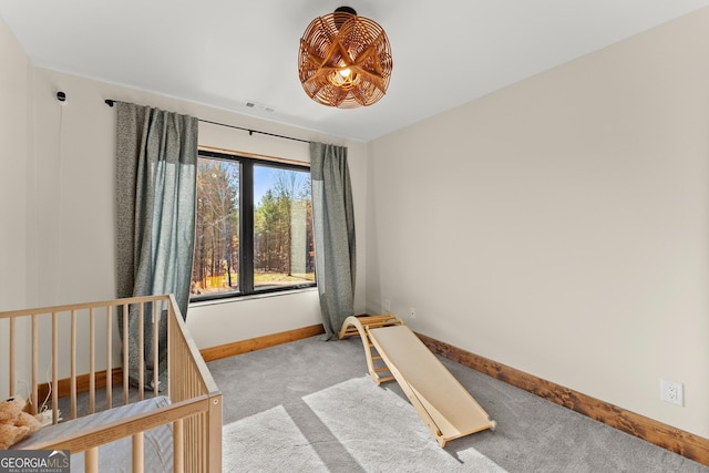 bedroom featuring light carpet and a nursery area