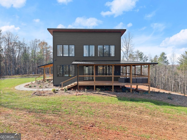 rear view of house with a yard and a deck