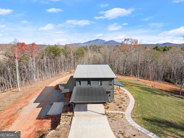 exterior space with a mountain view and a front lawn