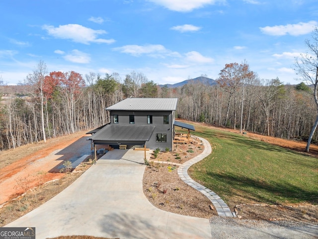 view of front of house with a mountain view and a front lawn