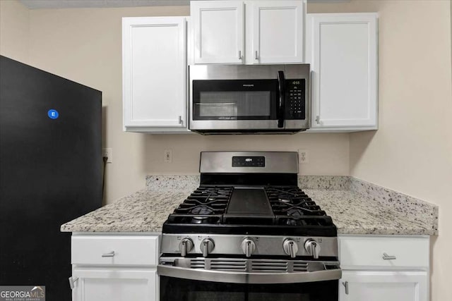 kitchen featuring white cabinets, light stone countertops, and stainless steel appliances