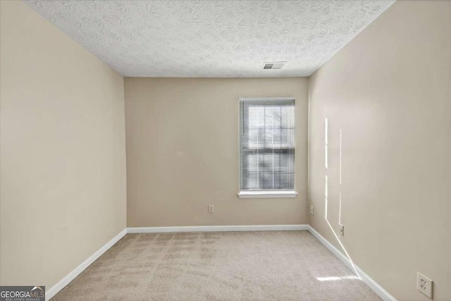 unfurnished room with light carpet and a textured ceiling