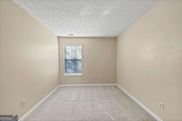 carpeted spare room with a textured ceiling