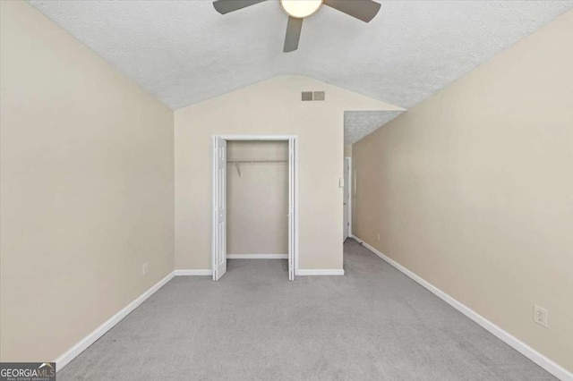 unfurnished bedroom featuring ceiling fan, light carpet, and a textured ceiling