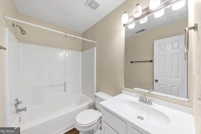 full bathroom featuring vanity, tub / shower combination, a textured ceiling, and toilet