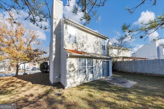 rear view of property featuring a lawn