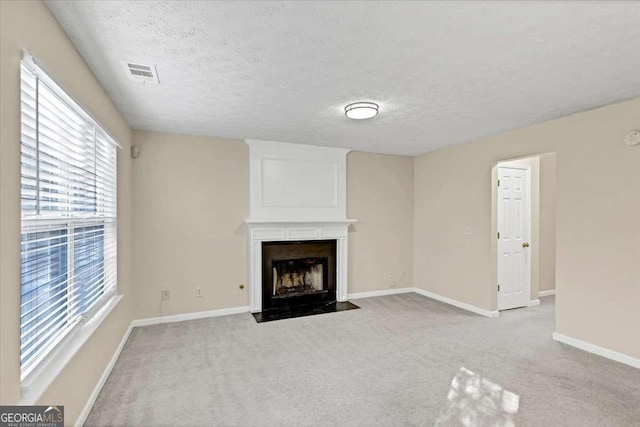 unfurnished living room featuring a textured ceiling and light carpet