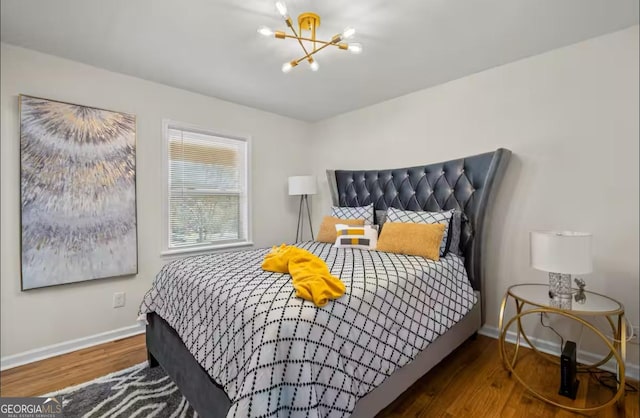 bedroom with hardwood / wood-style floors and a notable chandelier