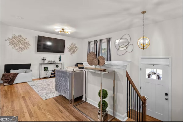 living room with wood-type flooring, a healthy amount of sunlight, and a notable chandelier