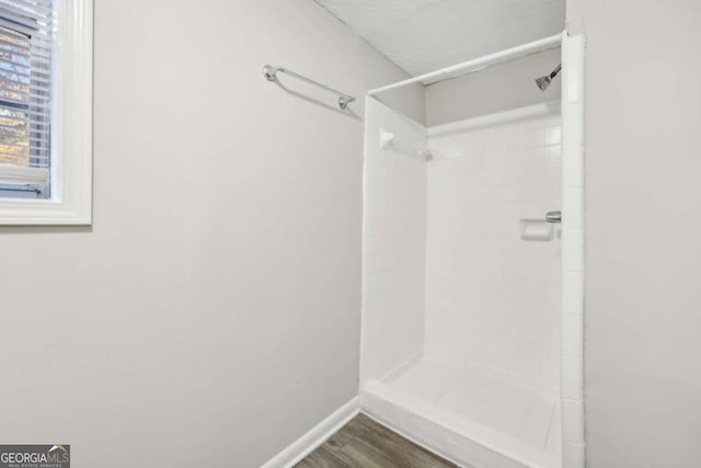 bathroom with wood-type flooring and walk in shower