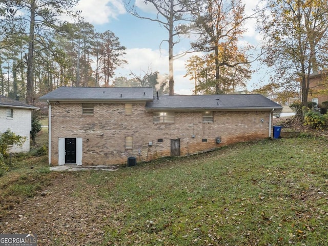 rear view of property featuring a yard and central air condition unit