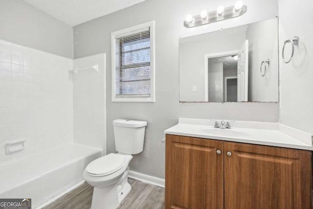 full bathroom with hardwood / wood-style floors, vanity, toilet, and  shower combination