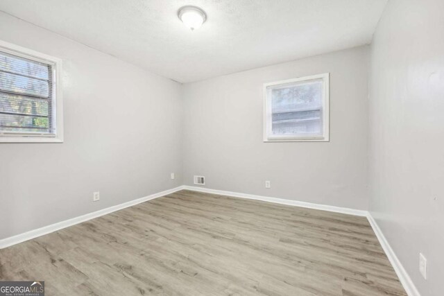 unfurnished room with light wood-type flooring