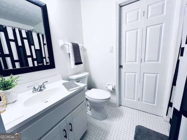 bathroom with curtained shower, toilet, a textured ceiling, vanity, and tile patterned flooring