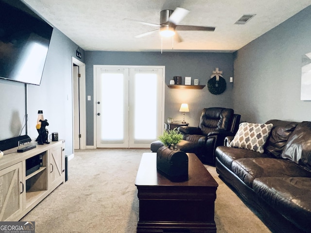 living room with light carpet, ceiling fan, visible vents, and baseboards