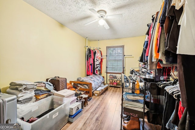 interior space with ceiling fan, wood-type flooring, and a textured ceiling