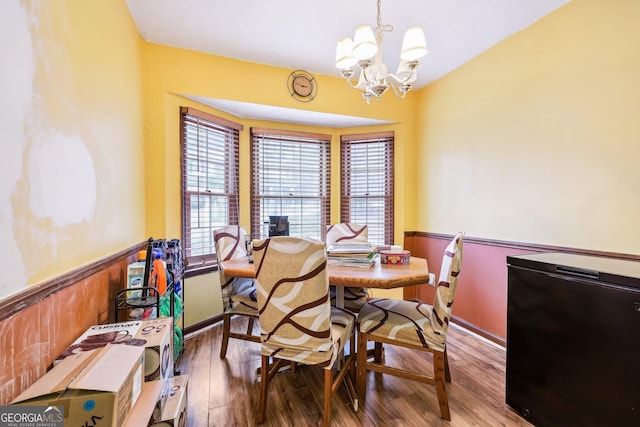 dining space featuring hardwood / wood-style floors and a notable chandelier