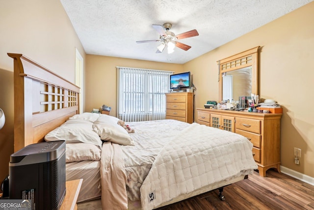 bedroom featuring ceiling fan, dark hardwood / wood-style flooring, and a textured ceiling