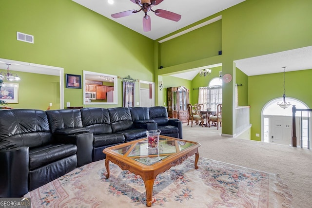 living room featuring carpet floors, high vaulted ceiling, and ceiling fan with notable chandelier