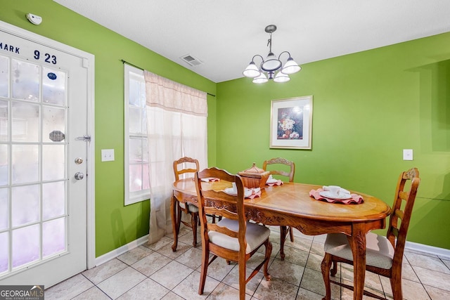 dining area featuring a wealth of natural light, light tile patterned floors, and a notable chandelier