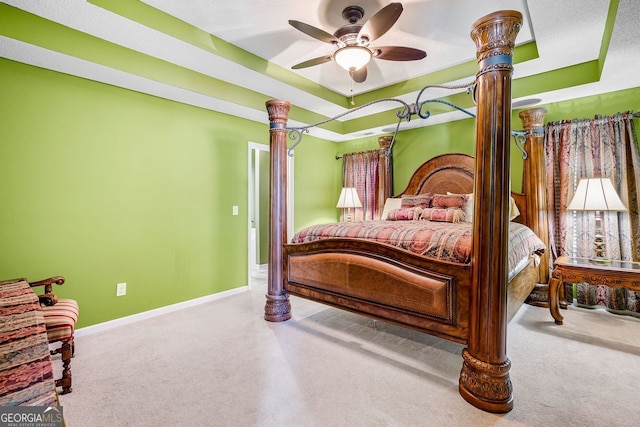 bedroom with carpet, a raised ceiling, and ceiling fan