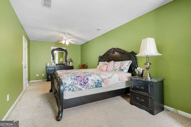 carpeted bedroom featuring ceiling fan and a textured ceiling