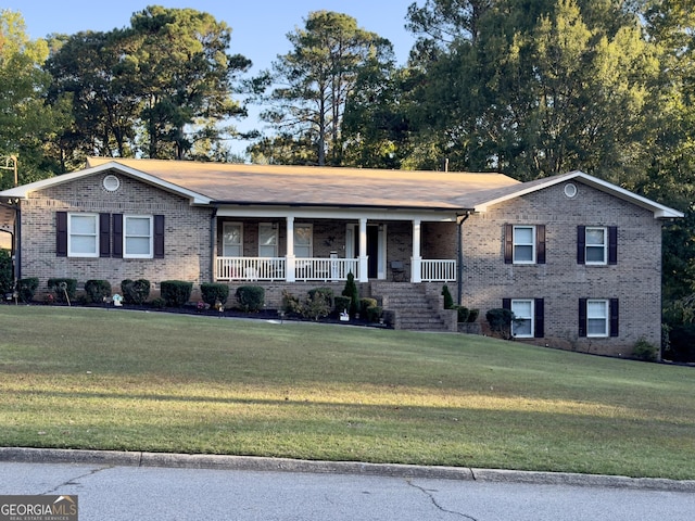 ranch-style home featuring covered porch and a front lawn