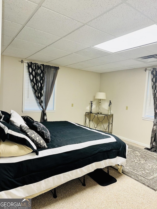 carpeted bedroom featuring a paneled ceiling