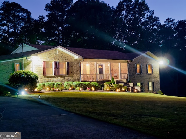 view of front facade with covered porch and a yard