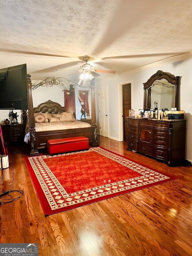 bedroom featuring hardwood / wood-style floors, ceiling fan, crown molding, and a textured ceiling